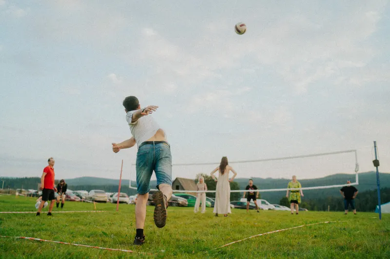 Meci de volei pe pajiștea festivalului, cu dealuri împădurite în fundal, la ediția din 2024