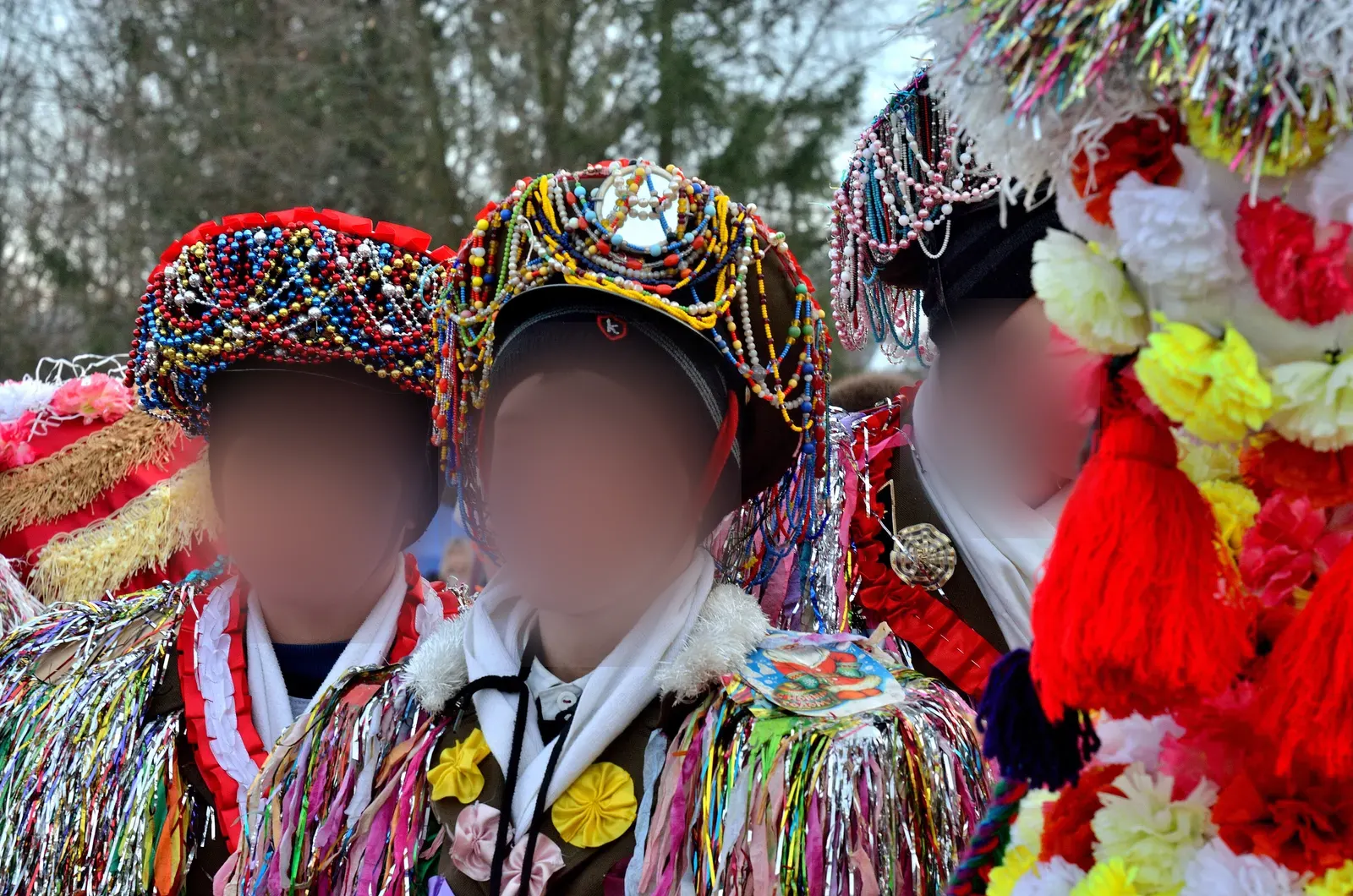 Flăcăi în costume de malancă, cu căciuli înalte acoperite cu mărgele și umeri din fâșii colorate, la un festival în muzeul în aer liber de la Cernăuți