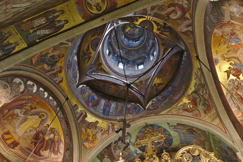 Interiorul bisericii privit în sus: turla cu Hristos Pantocrator în cupolă, îngeri și sfinți pe registrele de dedesubt, pe fond auriu